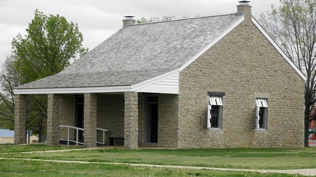 one story stone building with shutters