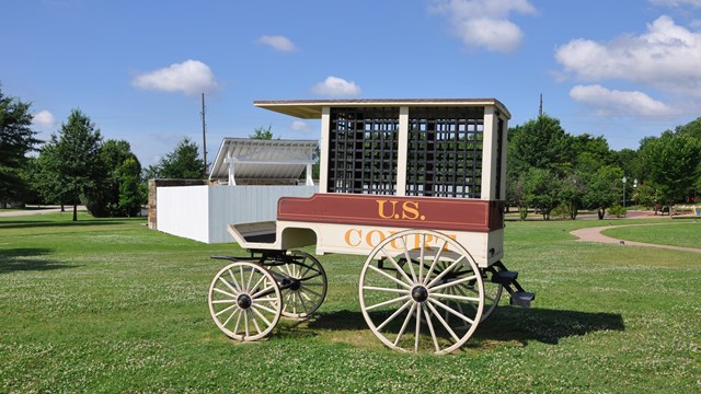 The red and white court wagon standing in front of the gallows.