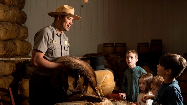 A ranger holding furs in the Fur Store at Fort Vancouver.