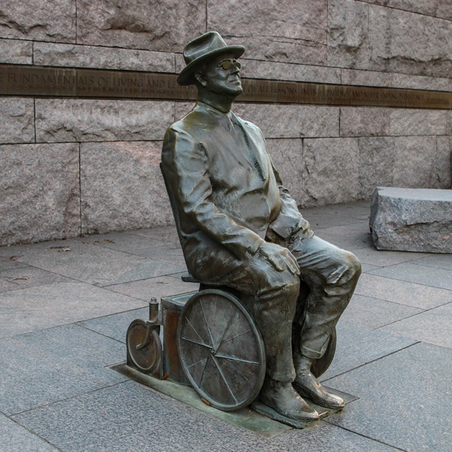 An empty wheelchair next to a desk.