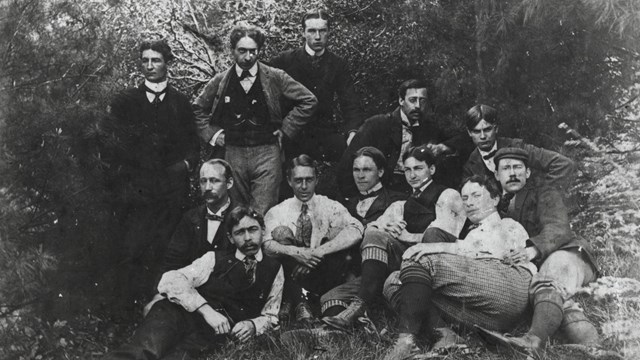 Group of men in suits and ties pose for picture. 