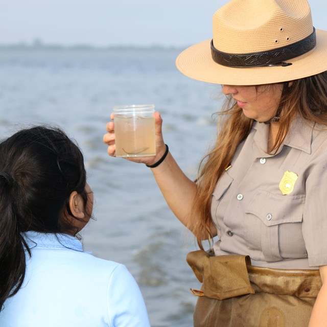 Ranger Audrey holding a jar containing fish