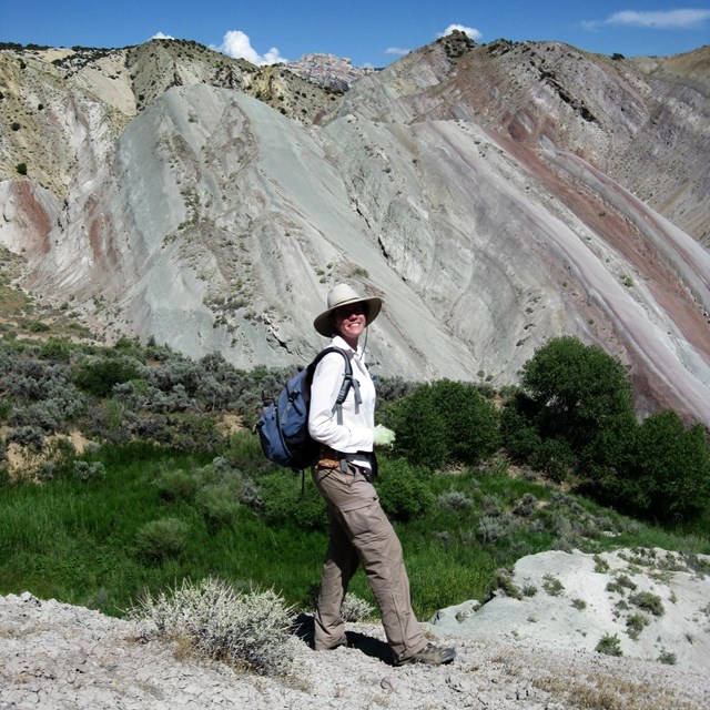 person near tilted rock layers