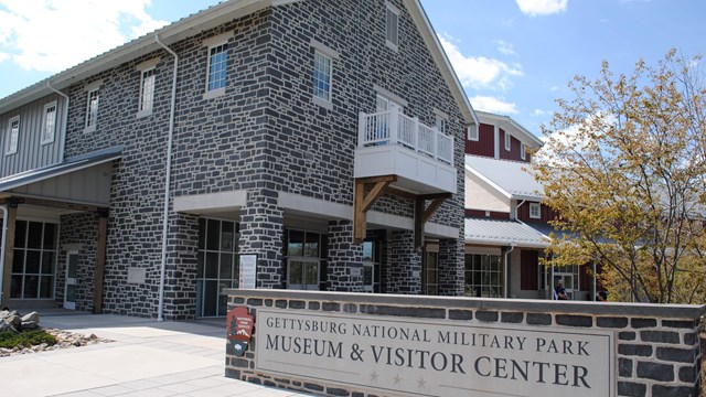 The park sign is visible in front of the corner of the Museum and Visitor Center.