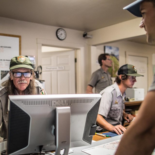 Park Rangers assists a visitor with their wilderness itinerary.