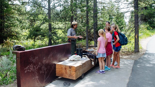 A ranger talks to kids outside.