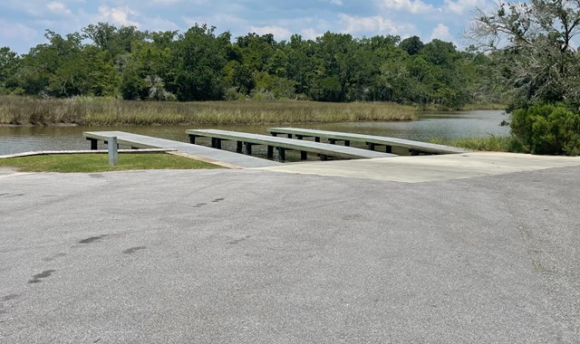 A National Park Service boat rests on top of blue green water.