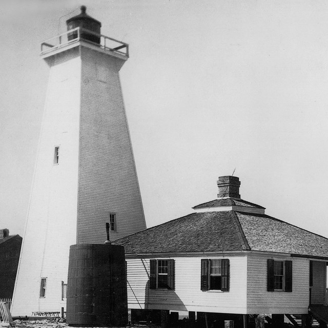 Black and white photo of the second Ship Island Lighthouse and one story keepers quarters.