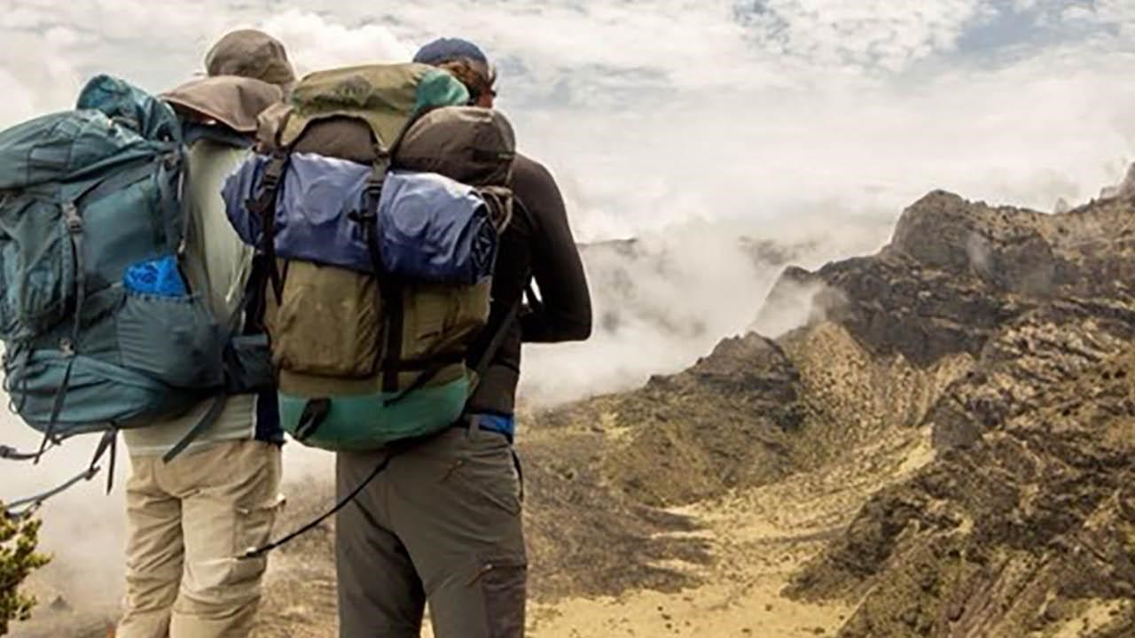 Two backpackers stand at edge of crater trail.