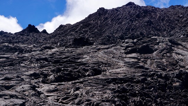 A cooled lava flow under blue sky