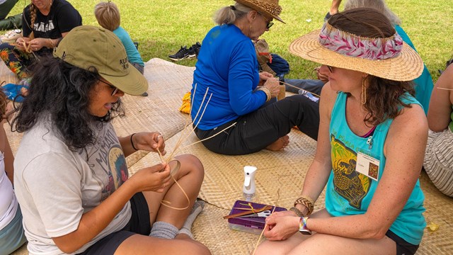 People learn to weave lauhala (pandanus leaves) into bracelets 