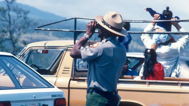 A National Park Ranger examining the 1984 eruption taking place on the slopes of Mauna Loa.