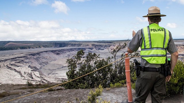 Two rangers standing in front of a large caldera.