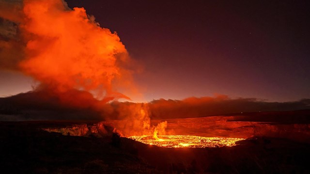 A glowing lava lake at night.