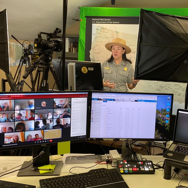 a park ranger gives a thumbs up in front of a computer and video equipment.