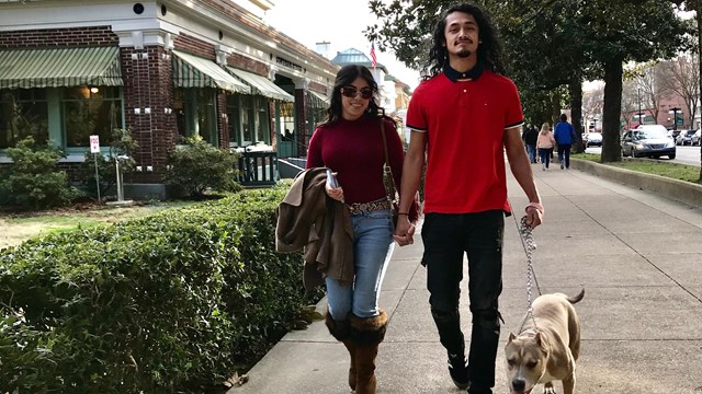 A man and woman walking their dog along Bathhouse Row.