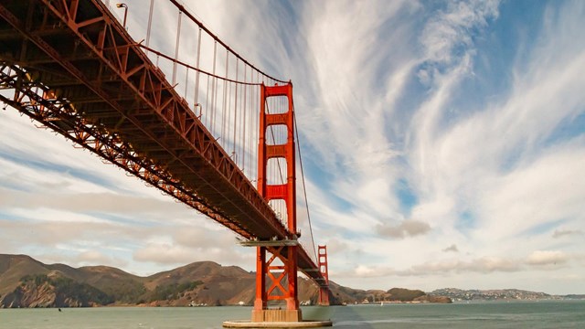 red huge bridge crossing water 