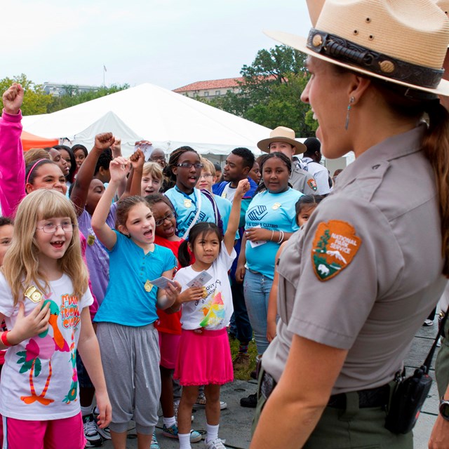 Group of kids wearing Junior Ranger badges holding hand up to take the Junior Ranger pledge