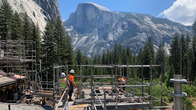 Construction crews and a large crane on a bridge under construction 