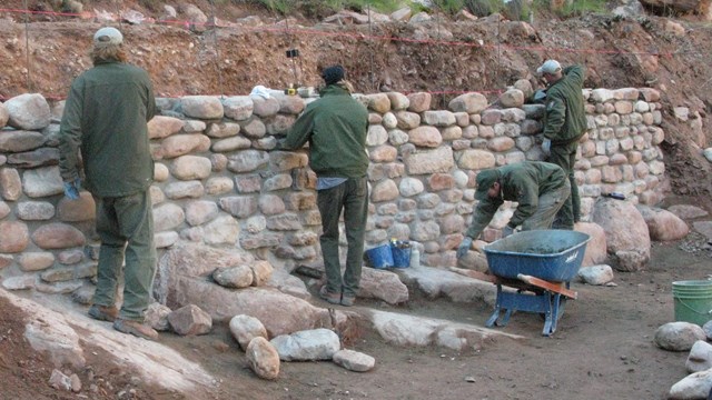 Trail crew working on a vertical stone wall