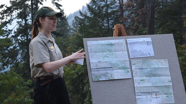 A volunteer stands next to a poster board.