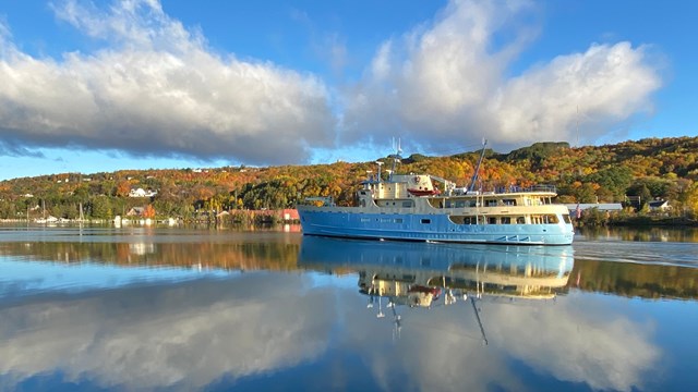 A large blue and cream colored motor vessel at dock.