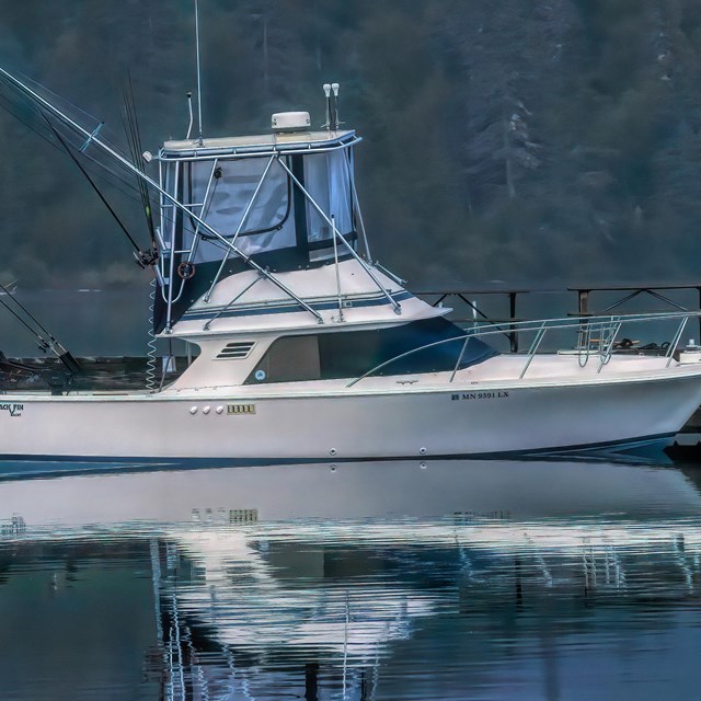 A white covered powerboat at dock.