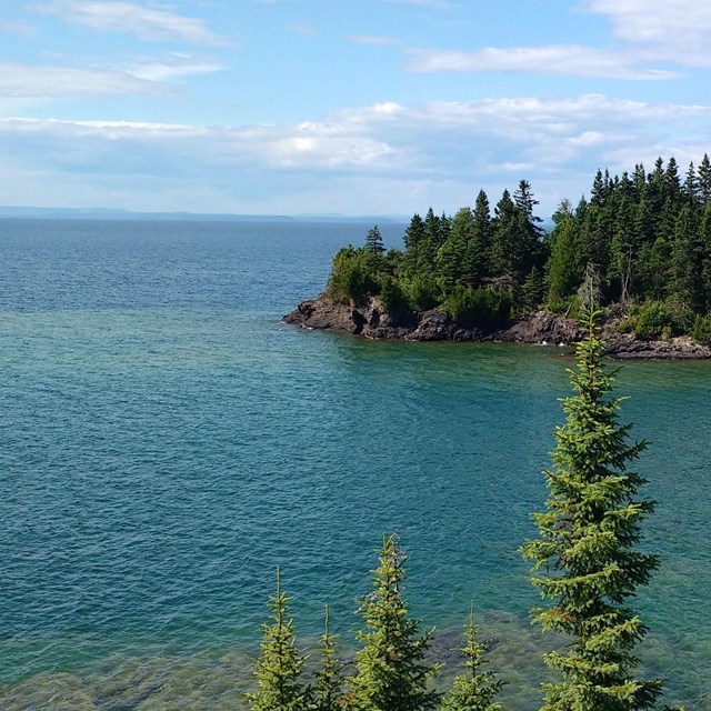 a panoramic view of a valey of lakes and trees, looking out towards Ontario in the distance