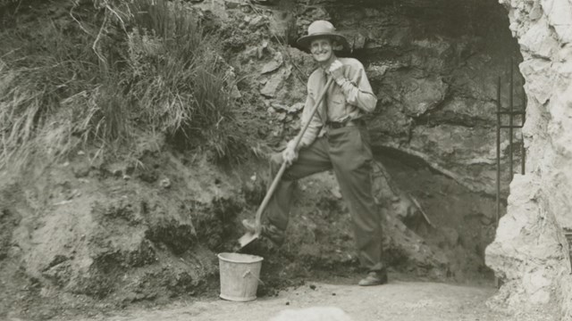 A Park Ranger standing in front of the Historic entrance to the cave.