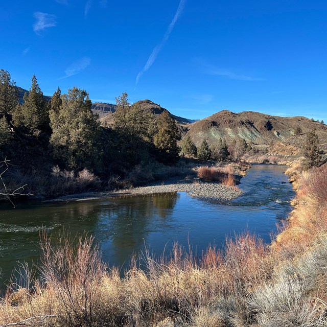 A river with a road running parallel to it.