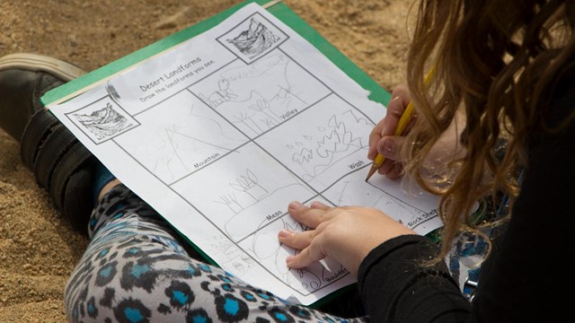 Color photo of a student completing a paper worksheet.