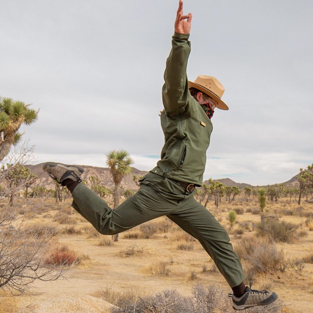 A park ranger jumps through the air.