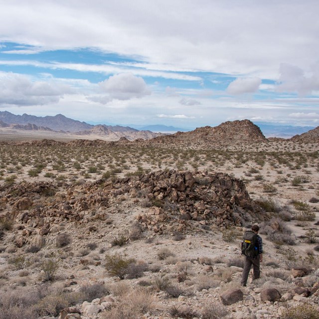 Color photo of a backpacker hiking through the Coxcomb Mountains.