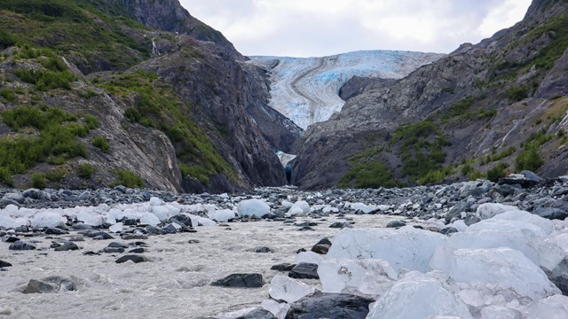 A stream with glacial ice and glacier in the distance
