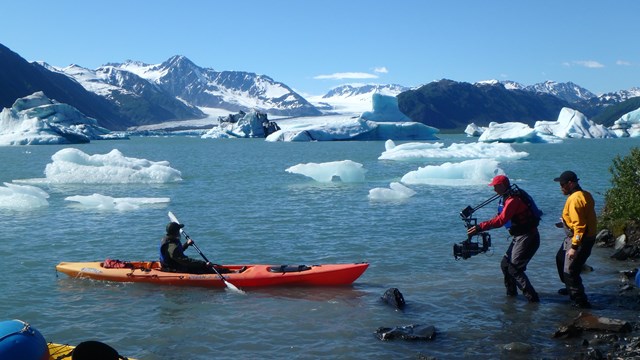 A kayaker filmed by a camera crew