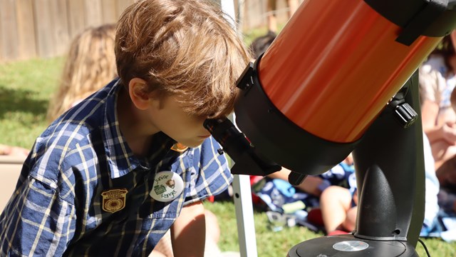 The Eclipse Explorer Junior Ranger book on a night sky blue background