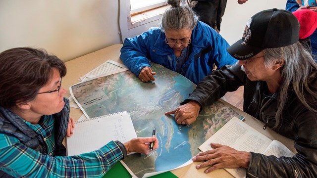 three people around a map