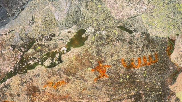 Close up of a rock with a orange-reddish image on it.