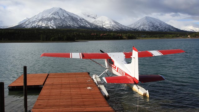 A floatplane parked at a dock in Port Alsworth