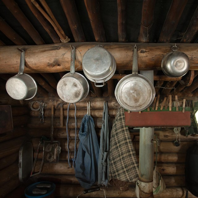 Pots and pans hang from a cabin wall