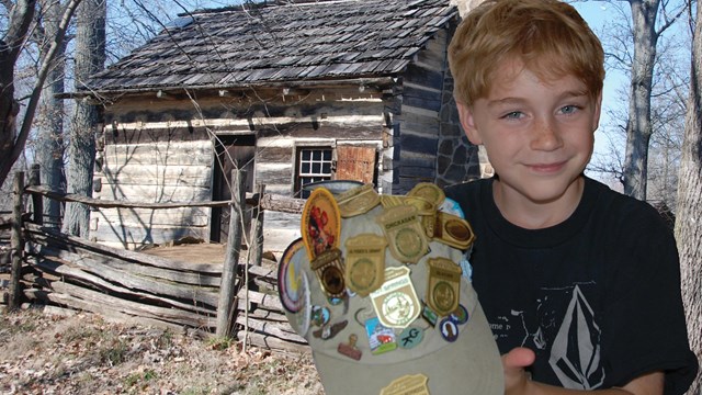 Kid showing Junior Rangers badges on his hat