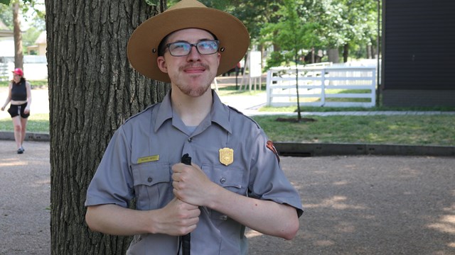 A ranger in a flat house smiles outside