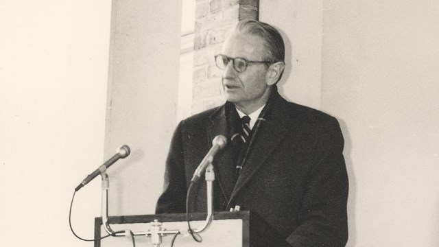 Laurance Rockefeller stands at a podium and delivers a speech at the opening of the Woodstock Inn