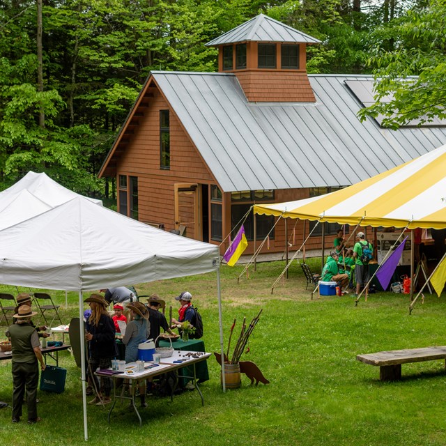 View from above of large event on lawn with tents and people walking around