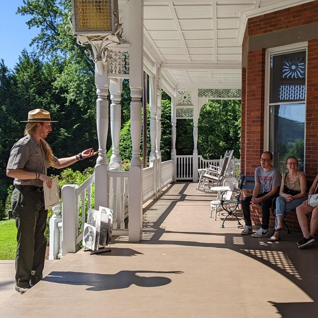 Ranger talks to a group of people on mansion porch