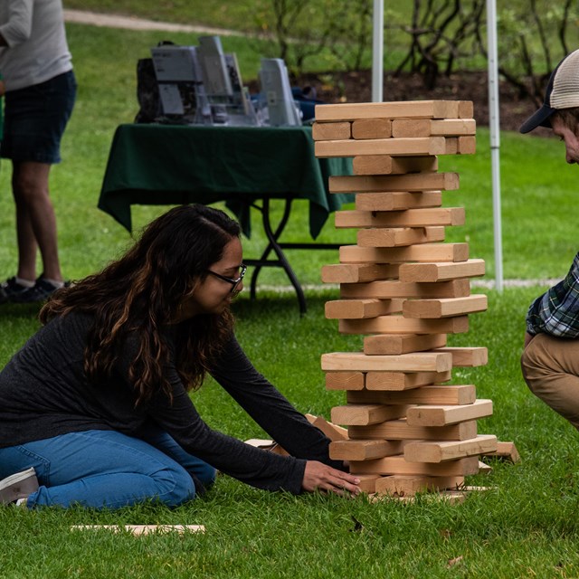 Two park visitors play giant Jenga outdoors