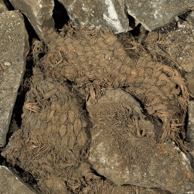 A plant fiber slipper sitting on the cave floor.