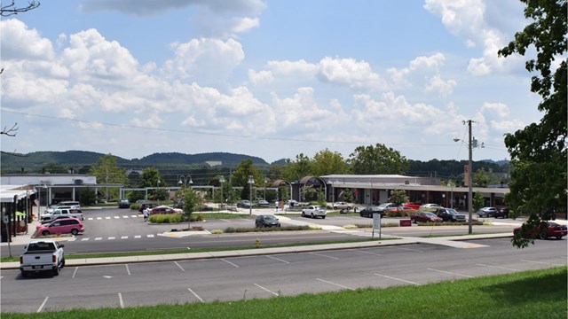 A small strip mall with parking in the foreground and background. 