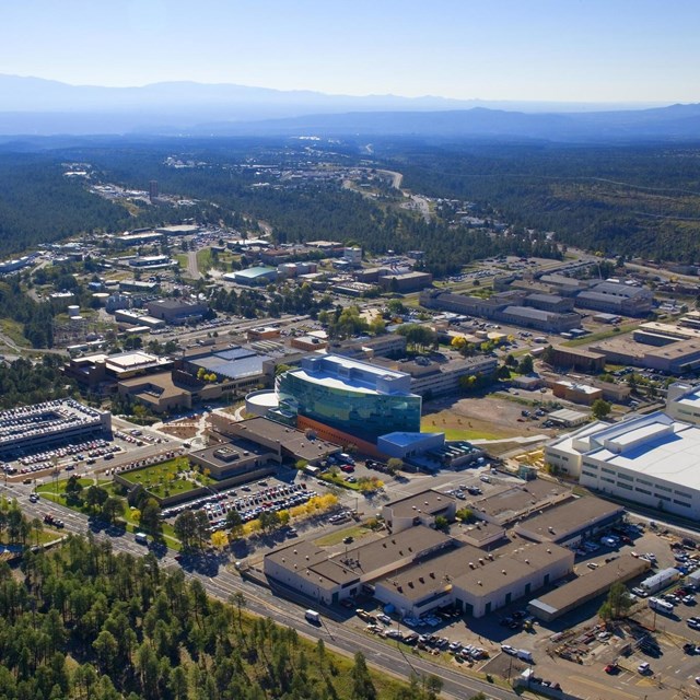 An aerial view of Los Alamos shows a landscape of mesas and canyons. 