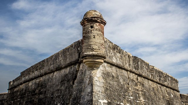 a corner of a stone fort against a blue sky